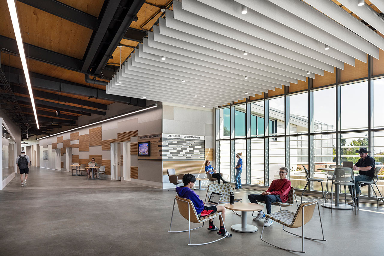 Student commons with large windows, wood ceiling features