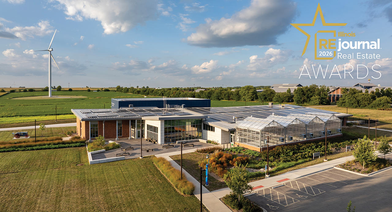 Aerial view of educational agriculture complex with solar panels and wind turbine