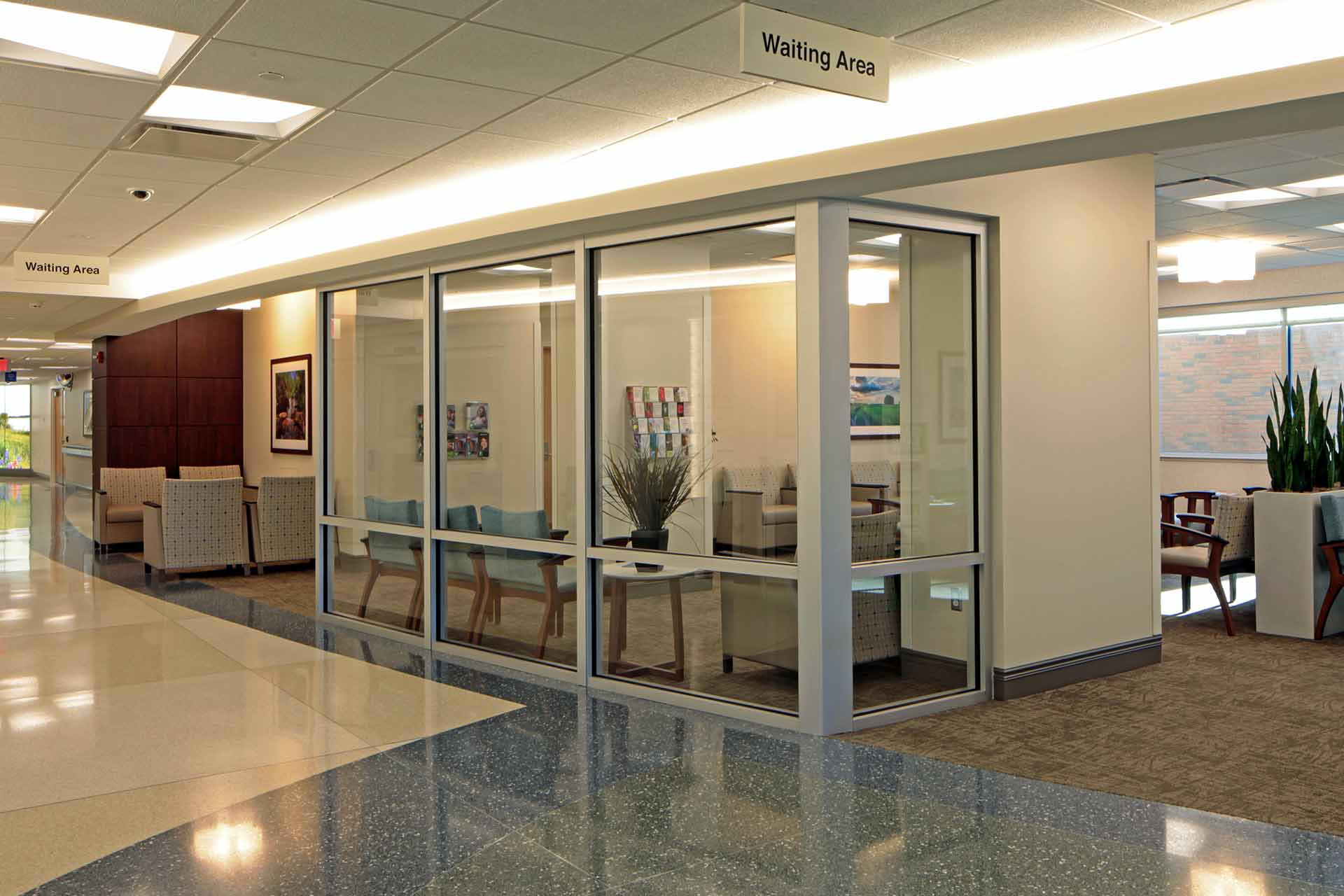 Modern hospital waiting area with glass walls, comfortable seating, and bright, welcoming interiors.
