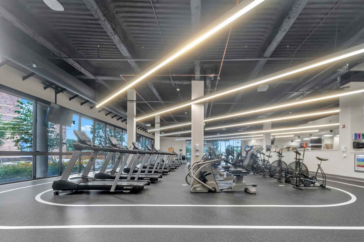 Modern cardiac rehabilitation gym with treadmills, exercise bikes, and fitness equipment in a bright, open space.
