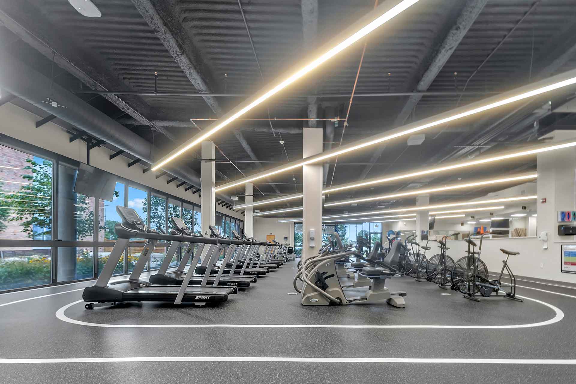 Modern cardiac rehabilitation gym with treadmills, exercise bikes, and fitness equipment in a bright, open space.