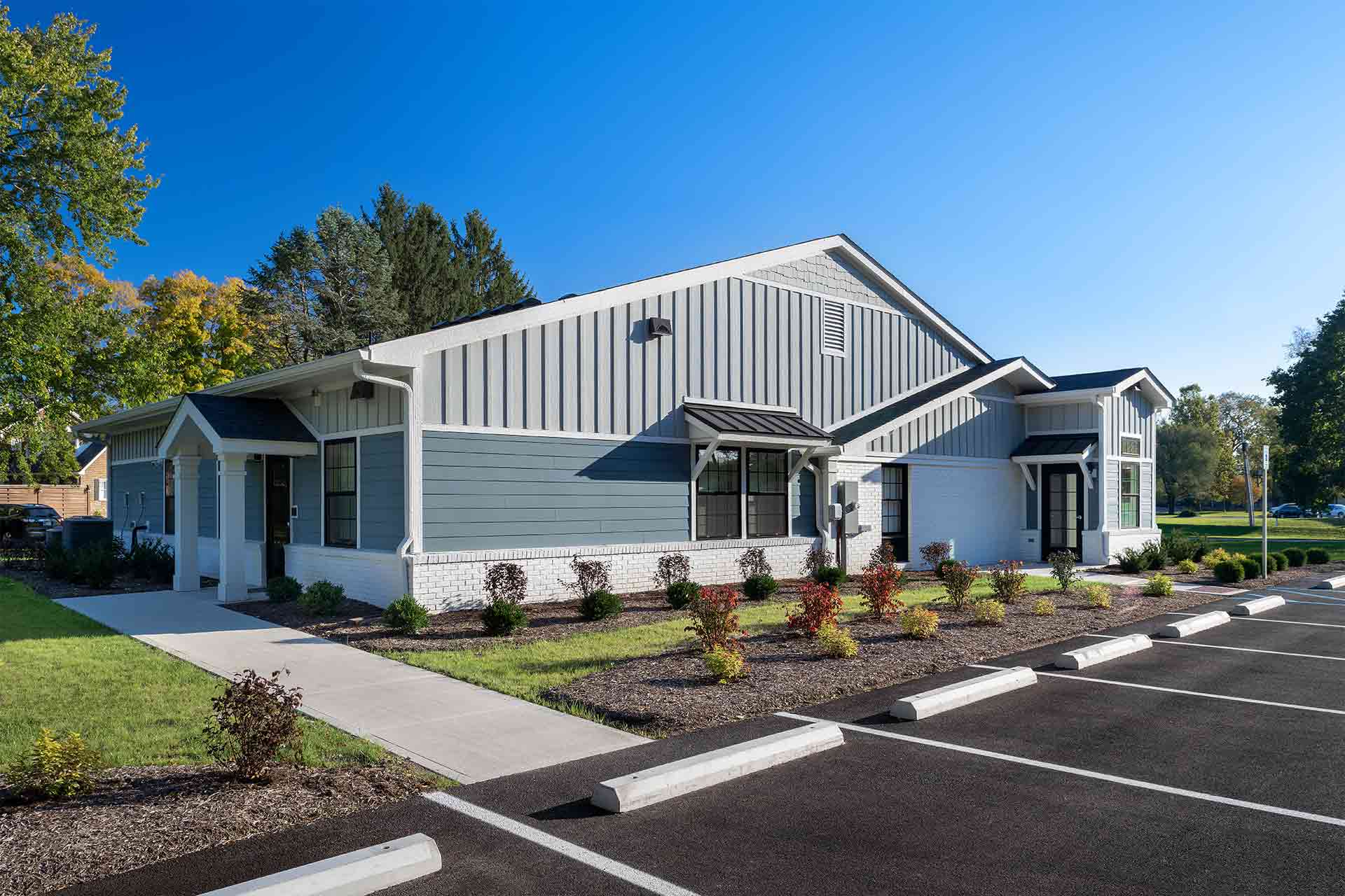 Exterior of a modern, single-story dental office building with light blue siding, white trim, and a parking lot.